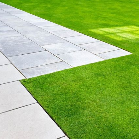 Sleek looking stone slabs and clean cut lawn.