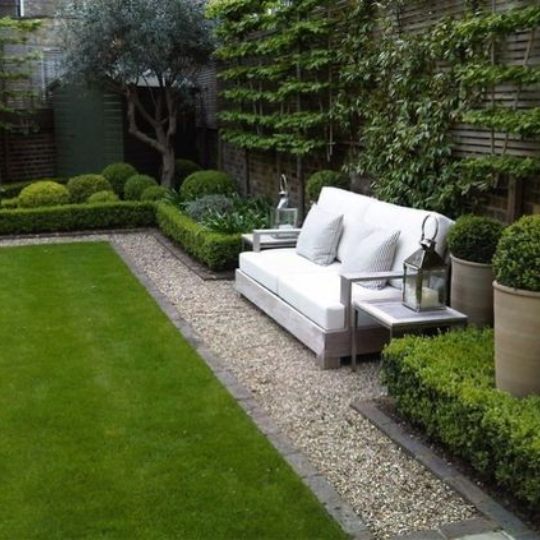 Crush rock filling in between bricks in a garden with white sofa.